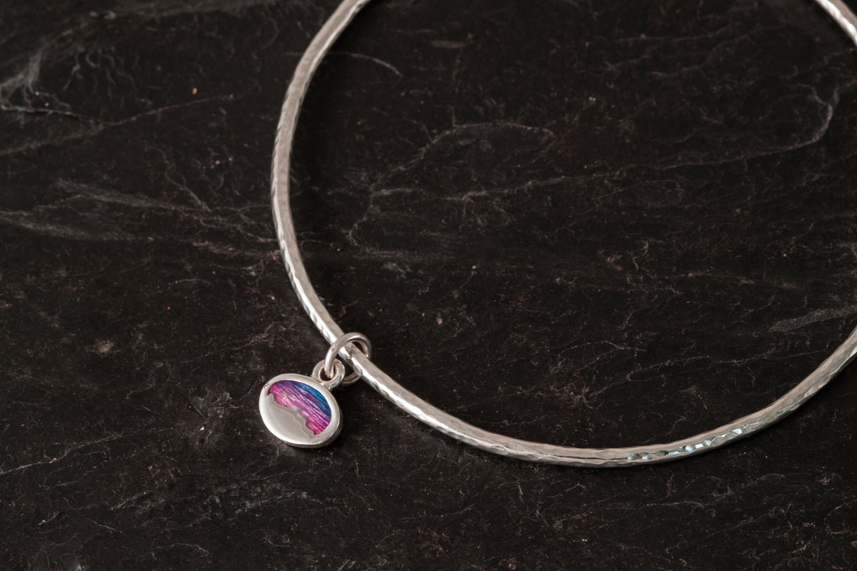Bangle with enamelled charm